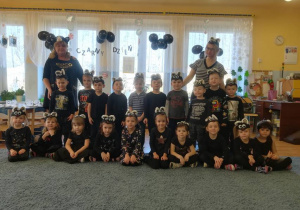 Zdjęcie grupowe – dzieci i nauczycielki przebrane za czarne koty.